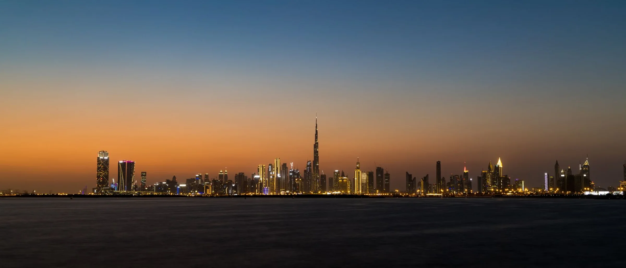 The Dubai skyline at twilight, seen across the water